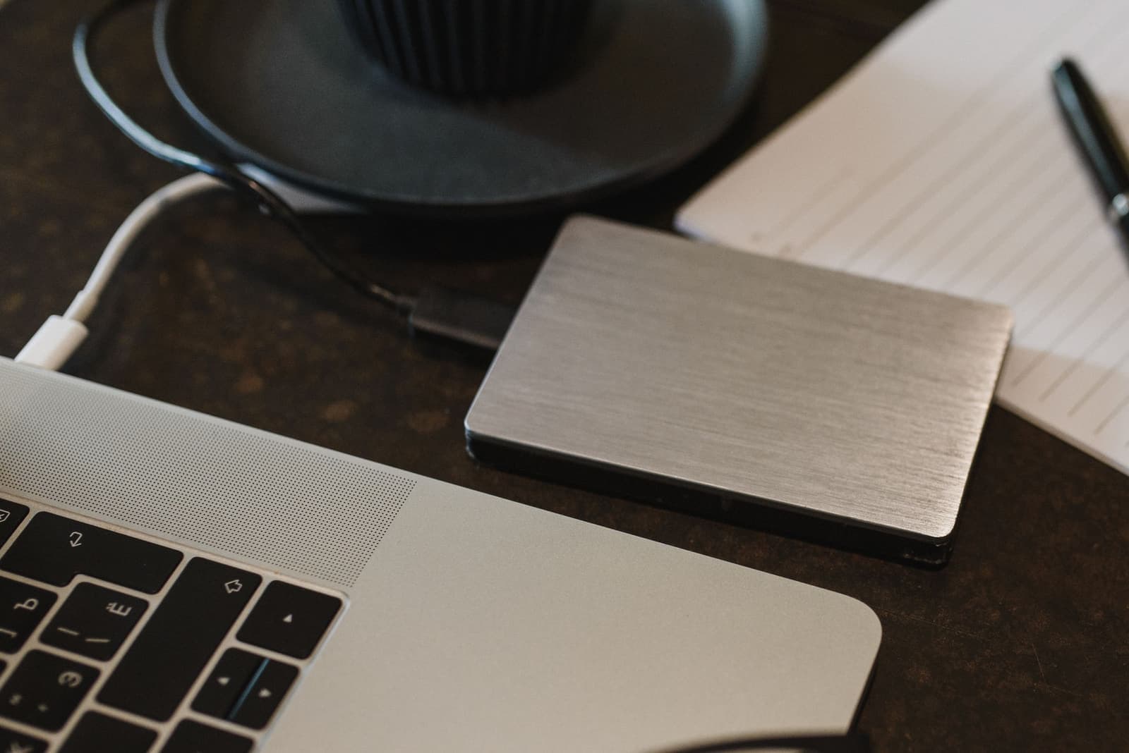 External backup drive connected to a laptop on a work desk