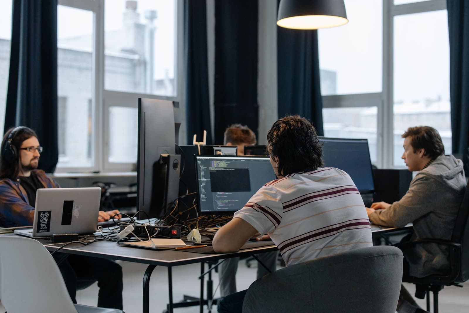 IT professionals working together at a bank of office monitors