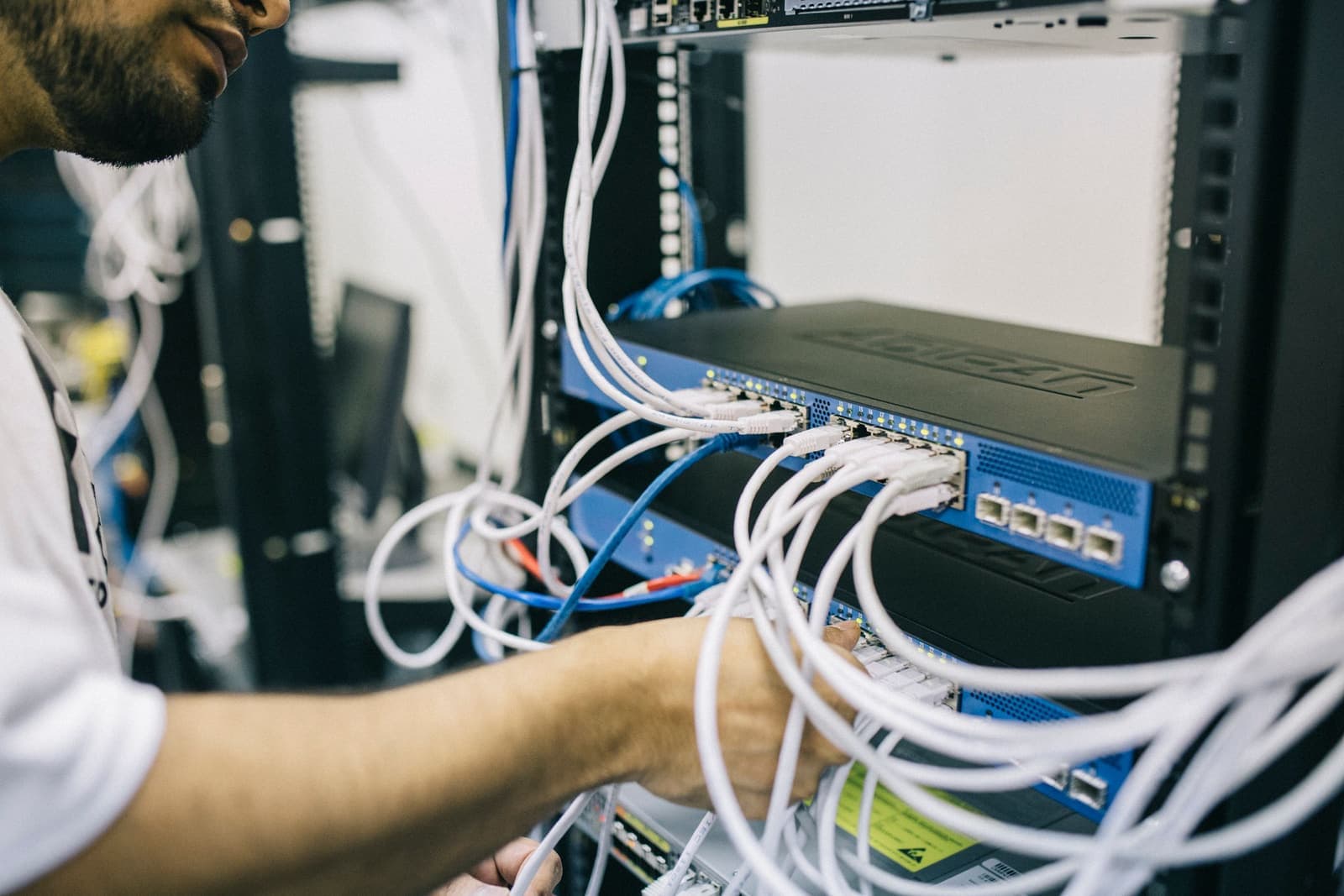 Network engineer connecting equipment in a server rack