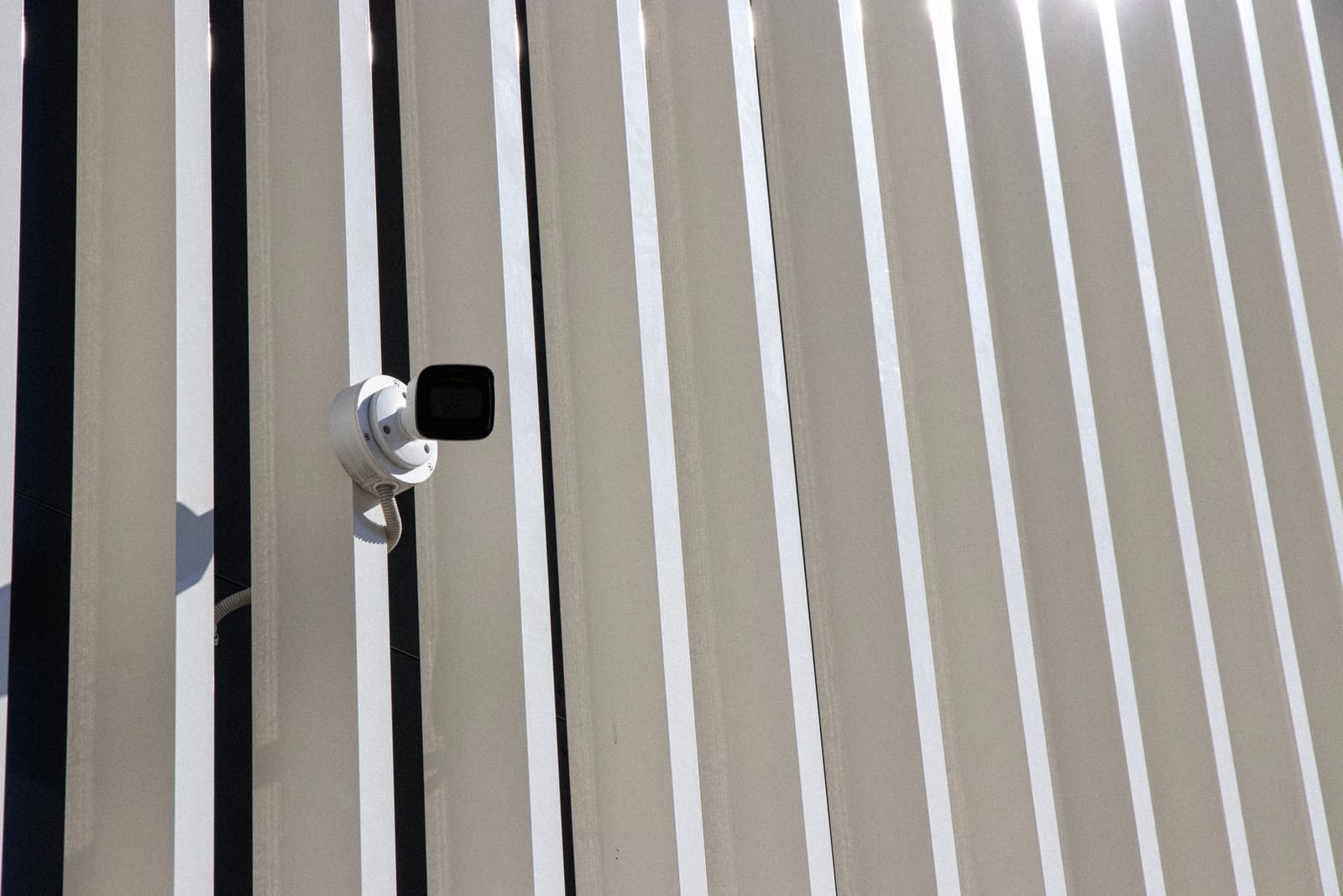 Security camera mounted against a clean modern building facade