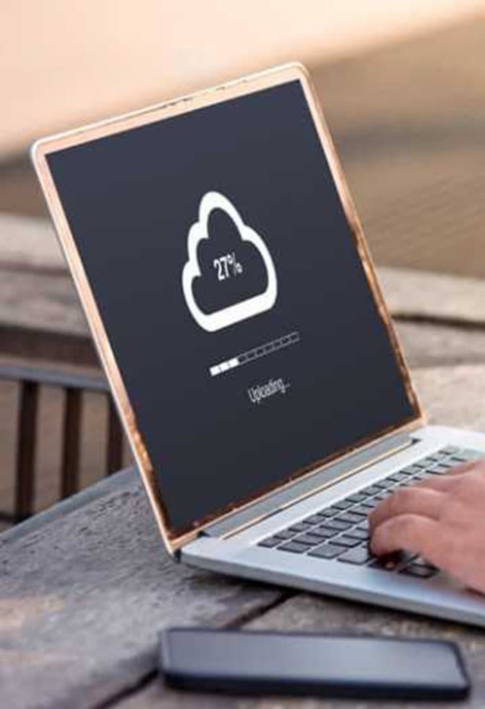 A laptop uploading data to cloud storage