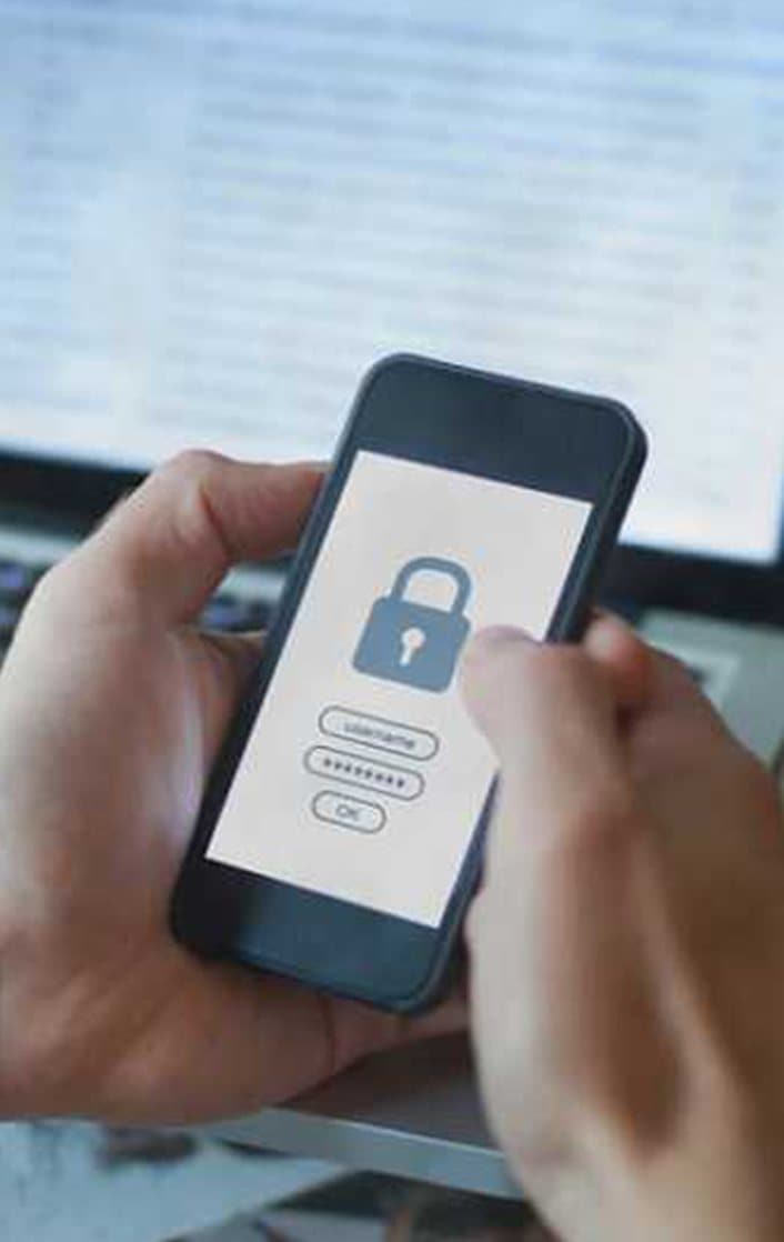 A secure login prompt on a phone held in front of a workstation
